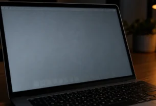 MacBook Pro screen showing a faint ghost image of the menu bar and Dock on a gray background